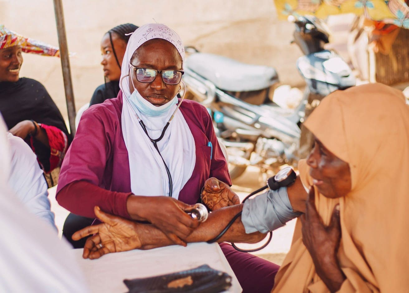 Afya1 clinician checking blood pressure during institutional outreach